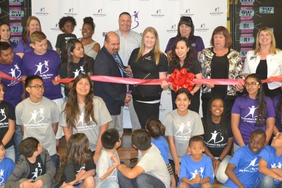 Lemoore Mayor Ray Madrigal cuts the ribbon Thursday, March 16, in the Lemoore Elementary School Cafeteria, to inaugurate the Big Brothers, Big Sisters "Bigs" program between the Lemoore High and Lemoore Elementary districts.